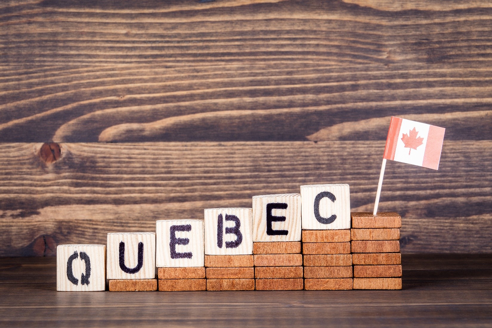 QUEBEC spelled out in block letters with a small Canadian flag at the end. 