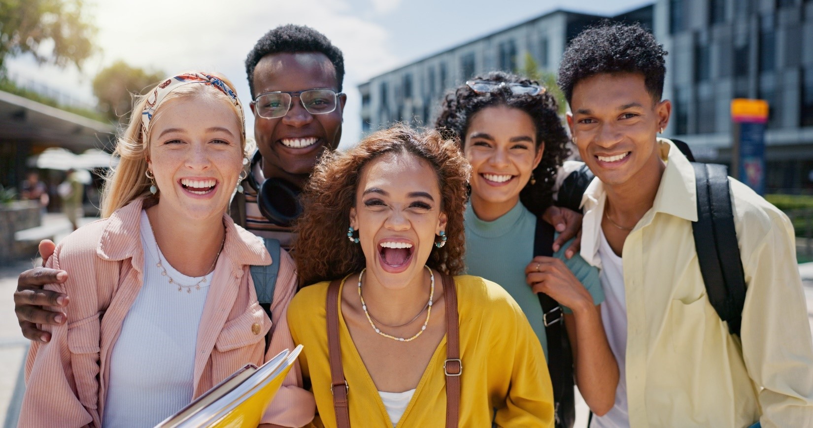 Five smiling international students posing for a picture.