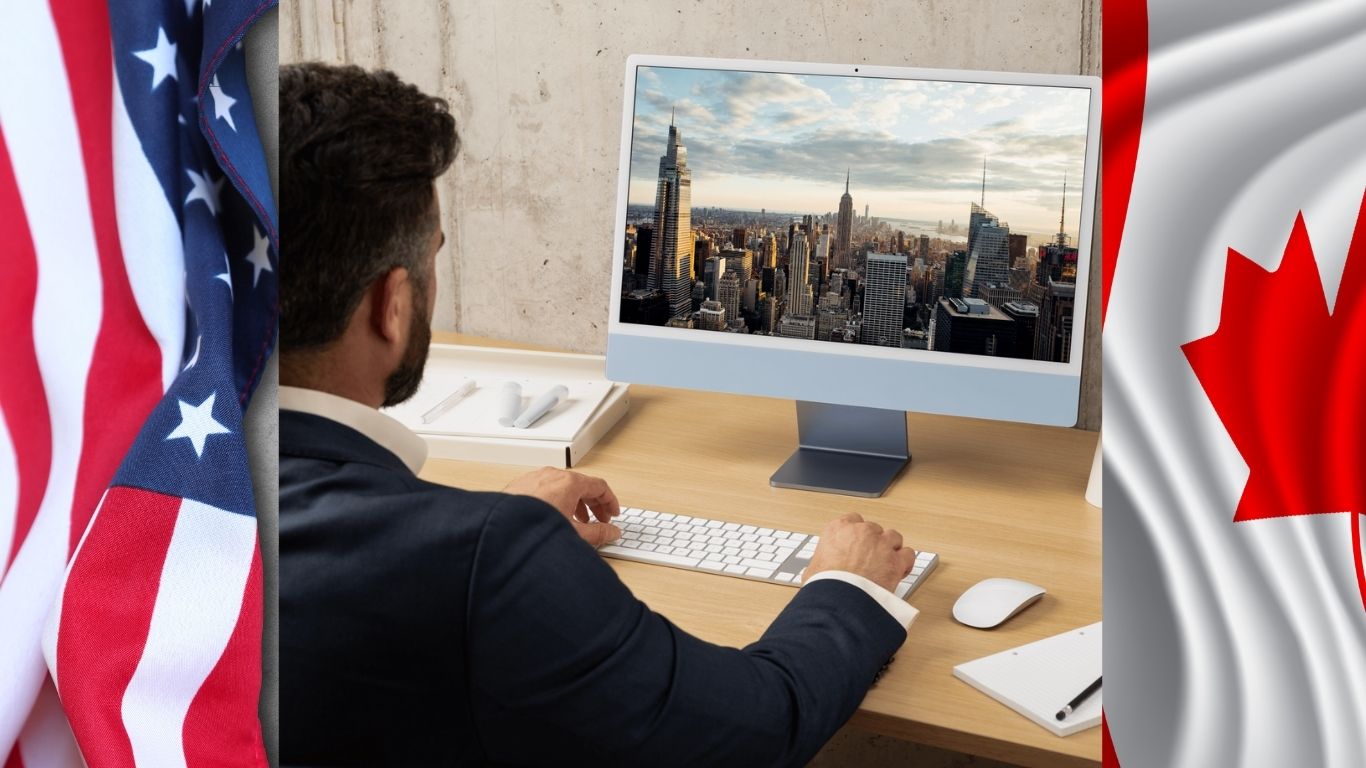 Businessperson looking at a city on computer, with both Canadian and American flags.