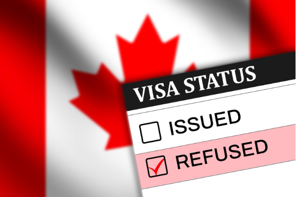 Graphic showing a text box titled “visa status” with boxes next to “issued” and “refused” and the “refused” box checked and a Canadian flag in the background.