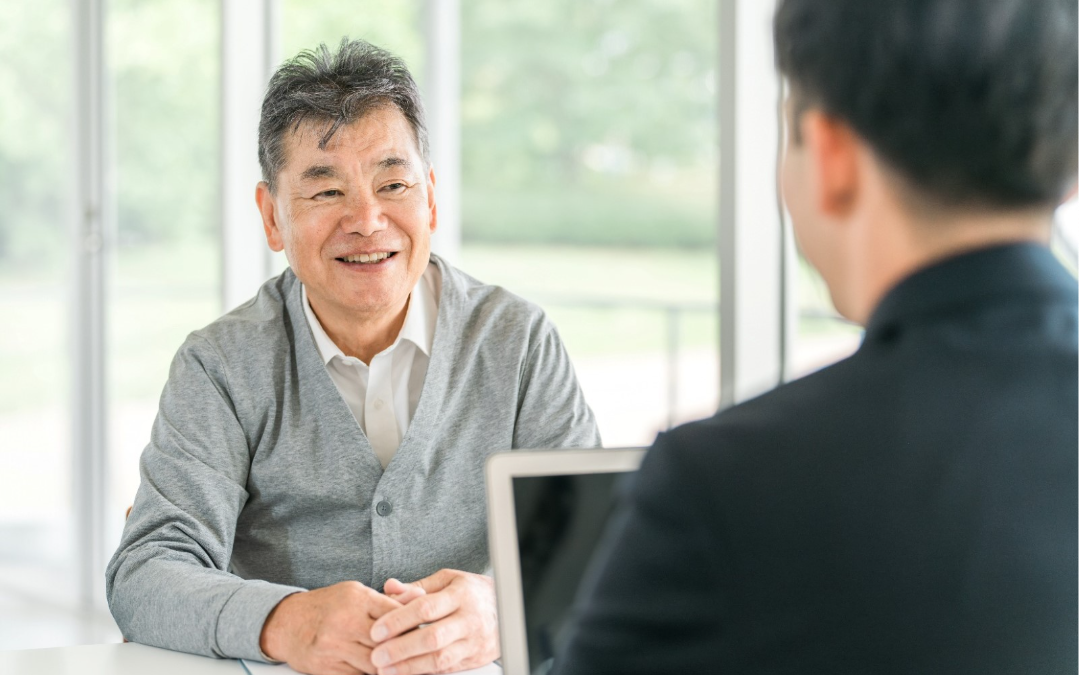 An elderly man speaking to an immigration consultant about his options.