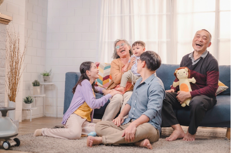 A multigenerational family sitting and laughing happily