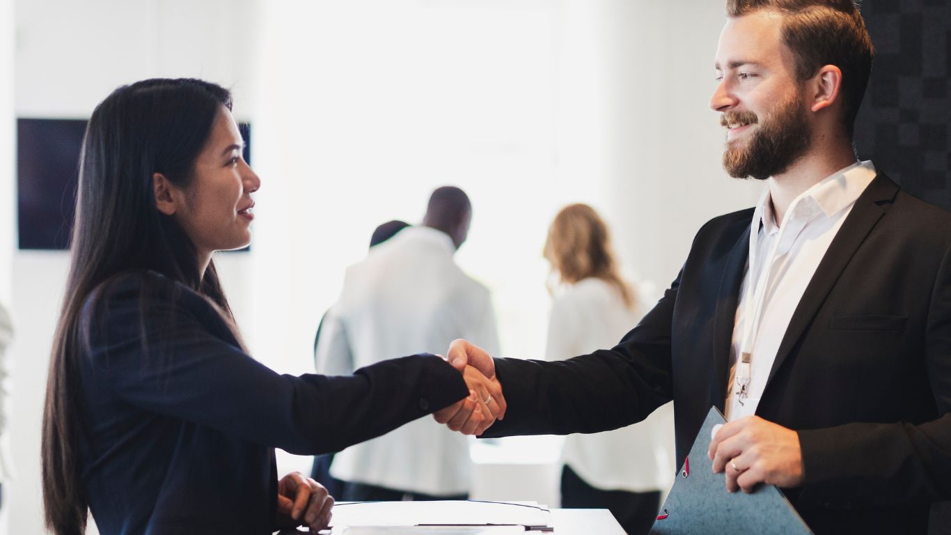 32 two people wearing business attire shaking hands