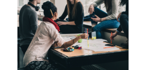 some young people gathered around a table with several documents on it