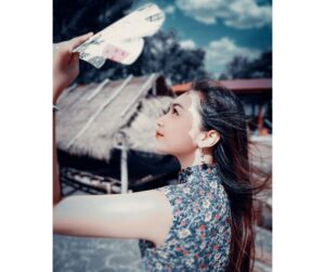 woman looking up at the sky while shielding her face from the sun