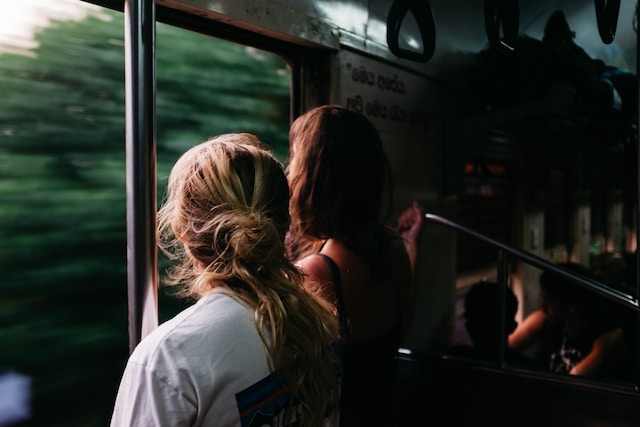 two people standing in a train looking out a window