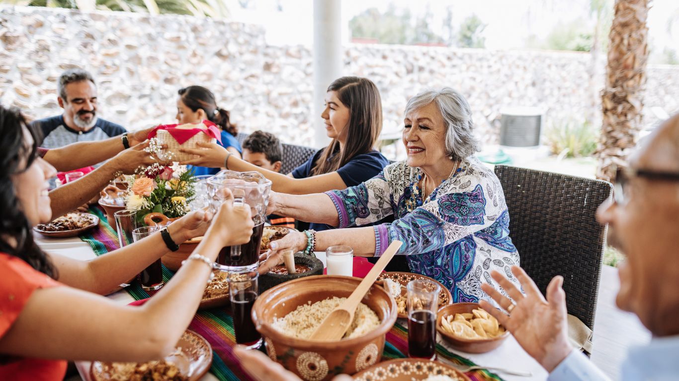 group of happy middle aged people enjoying dinner and celebratring